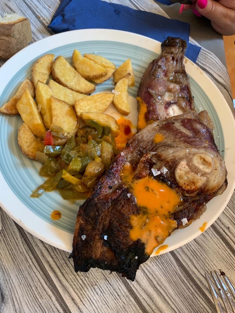 Churrasco sobre lecho de champiñones y pimientos con salsa y su mismo jugo